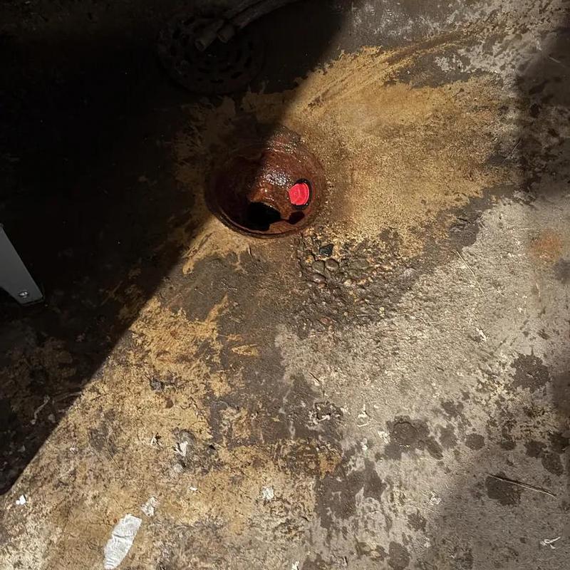 Floor drain with red plug in concrete floor