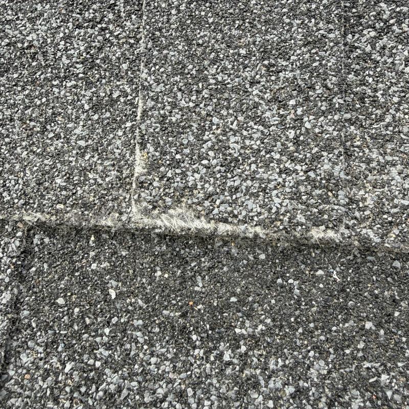 Asphalt shingle roof close-up showing wear and damage Asphalt shingle roof close-up showing wear and damage