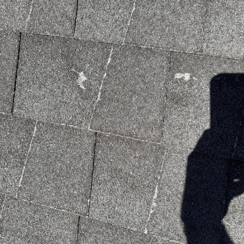 Asphalt shingles with hail damage marks on roof Asphalt shingles with hail damage marks on roof