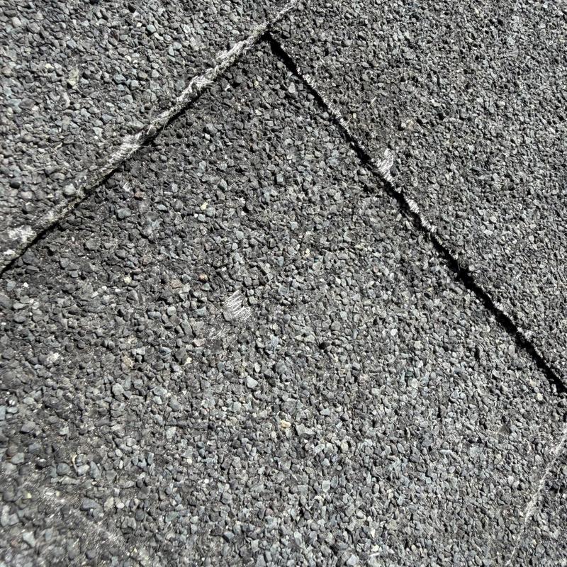 Asphalt roof shingles showing hail damage close-up Asphalt roof shingles showing hail damage close-up