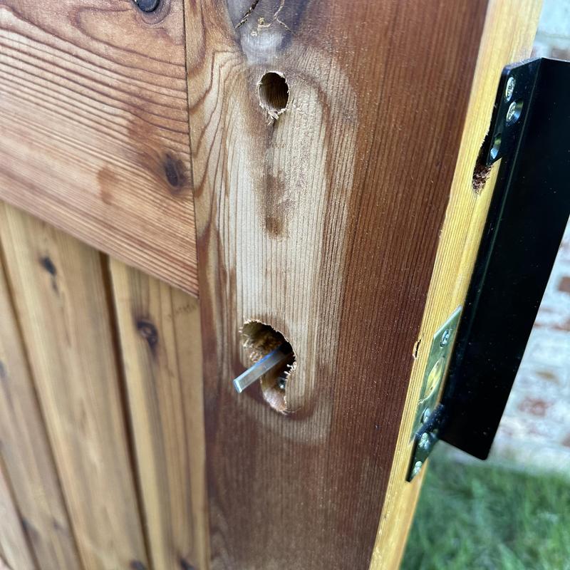 Double-sided keypad lock spindle on wood gate Double-sided keypad lock spindle on wood gate
