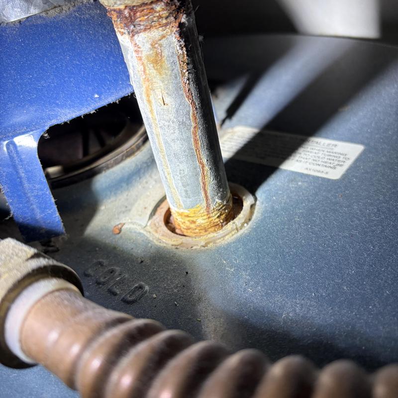 Rusty gas water heater pipe fitting with corrosion buildup Rusty gas water heater pipe fitting with corrosion buildup