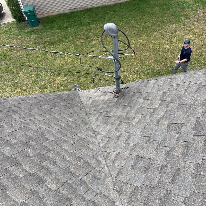 Roof shingles around vent pipe with inspection underway