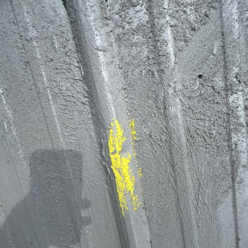 Metal roof panel with marked hail damage spot