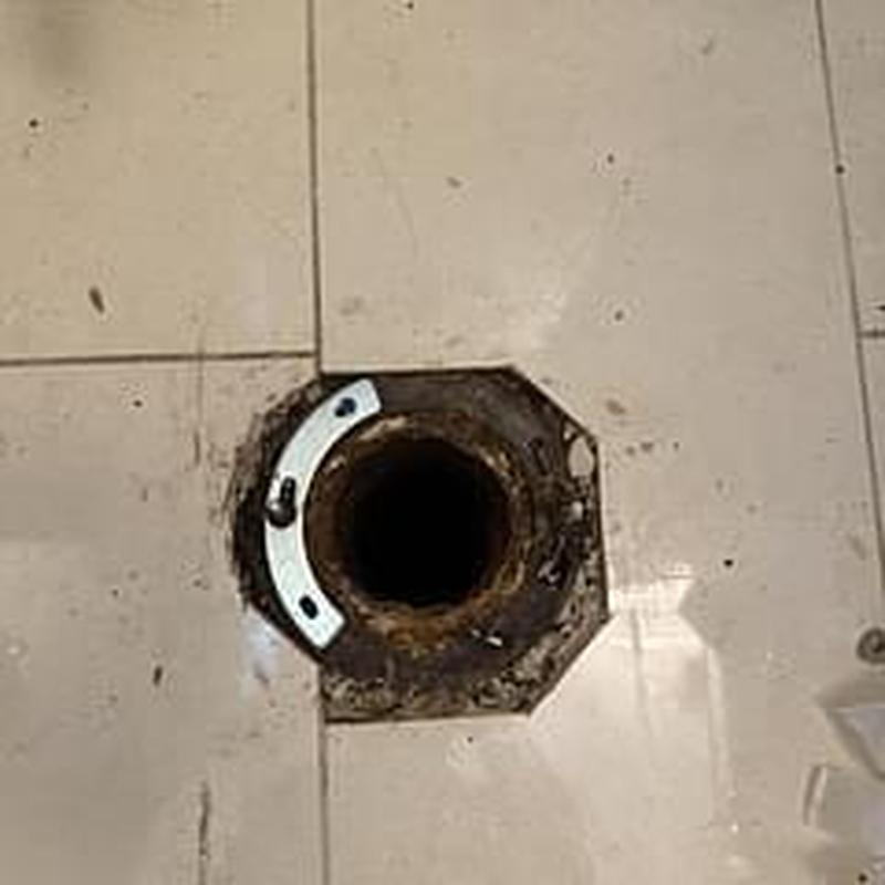 Toilet flange on bathroom floor before replacement