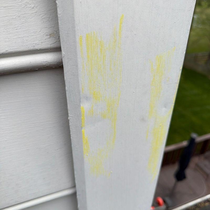 Wood trim with yellow chalk marking and dents