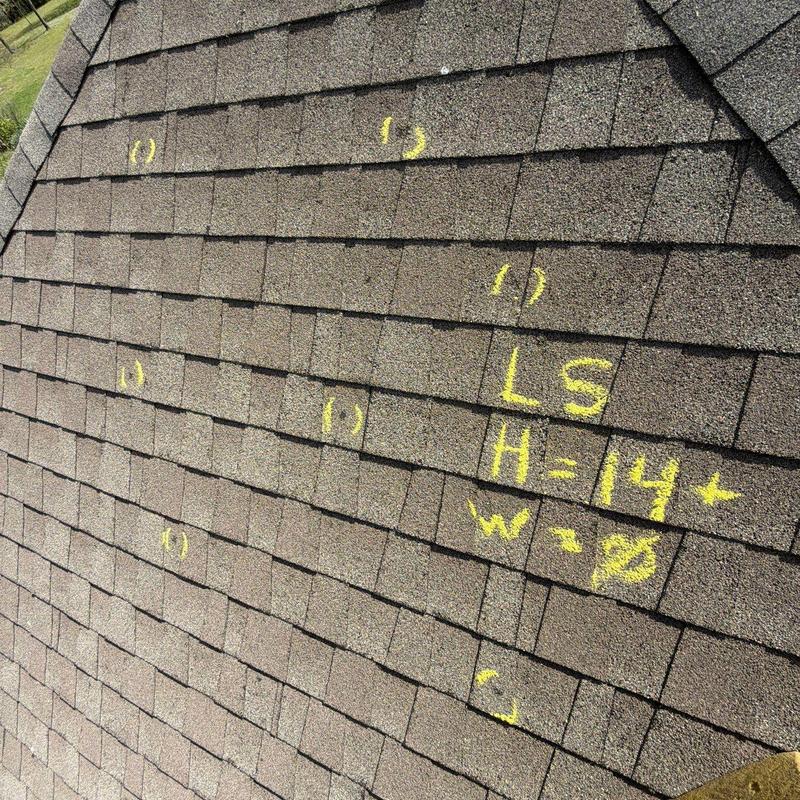 Asphalt roof shingles marked for hail damage inspection