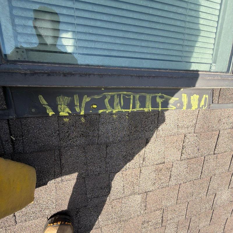 Roof shingles with marked hail damage near window trim