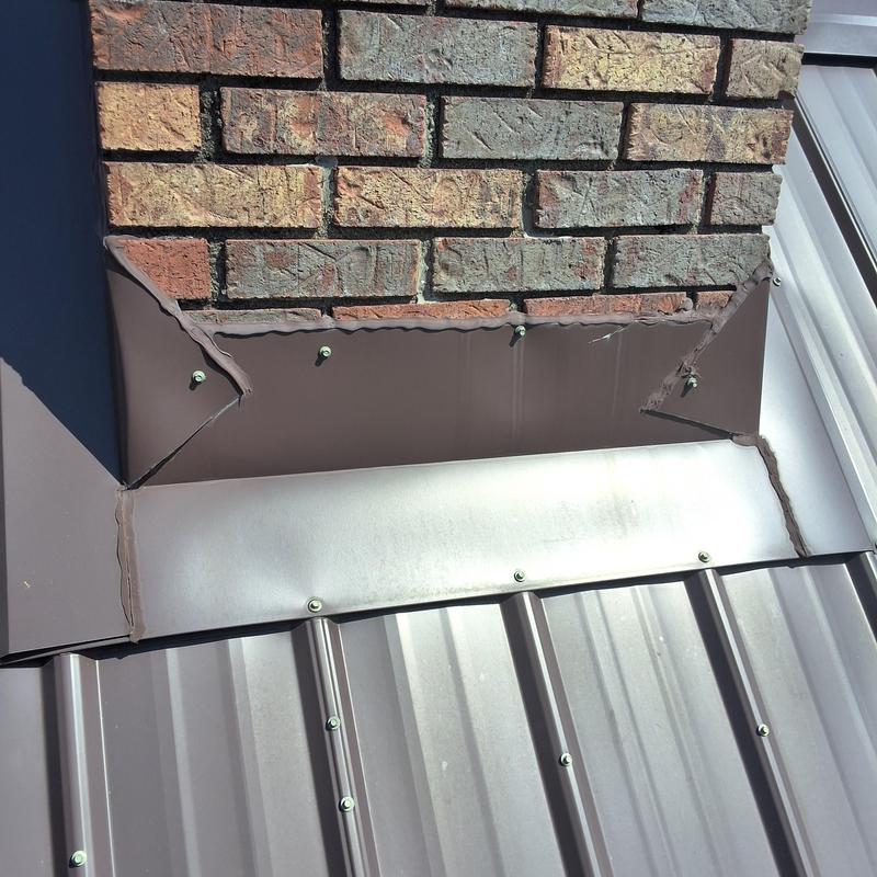 Chimney flashing and metal roof junction with sealant Chimney flashing and metal roof junction with sealant