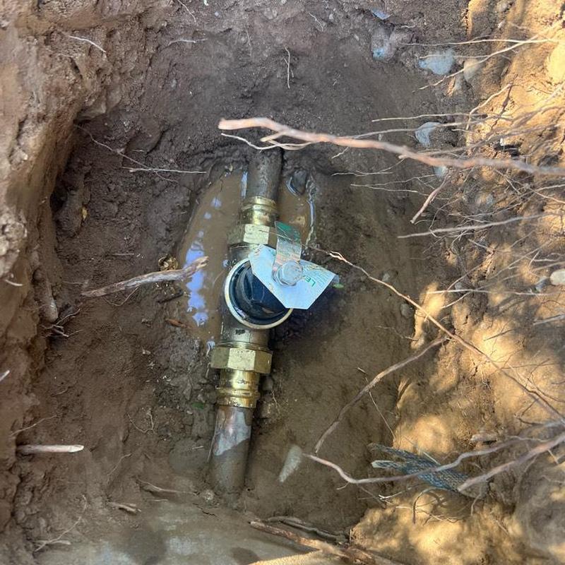 Pressure regulator valve installed in excavated soil hole