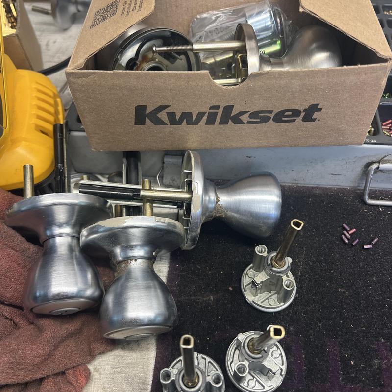 Kwikset door knobs and lock components on workbench Kwikset door knobs and lock components on workbench