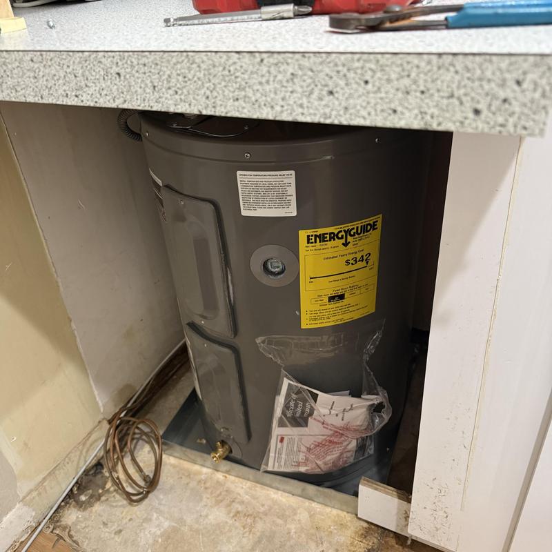 Water heater installed under countertop with tools nearby