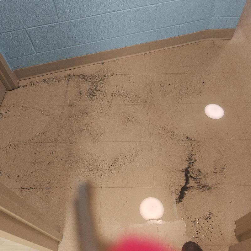 Main line drain with black debris on floor tiles Main line drain with black debris on floor tiles