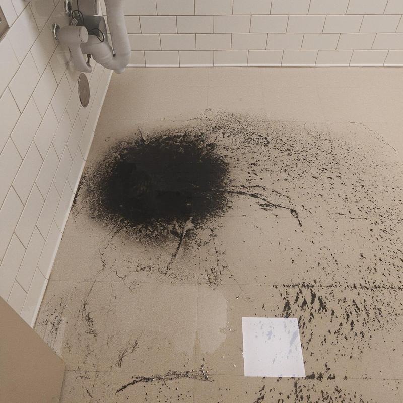 Bathroom floor drain with black sludge buildup Bathroom floor drain with black sludge buildup