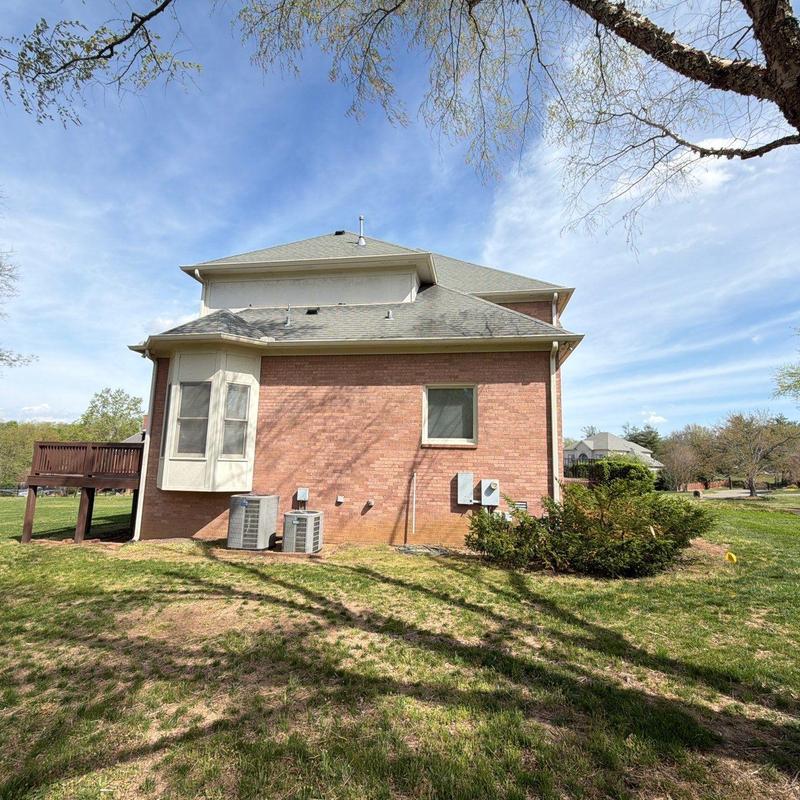 Roof shingles with hail damage on brick house