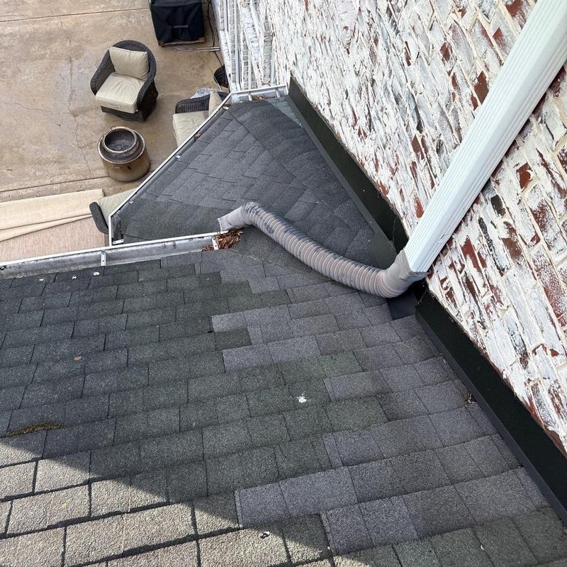 Architectural shingles and downspout on roof edge