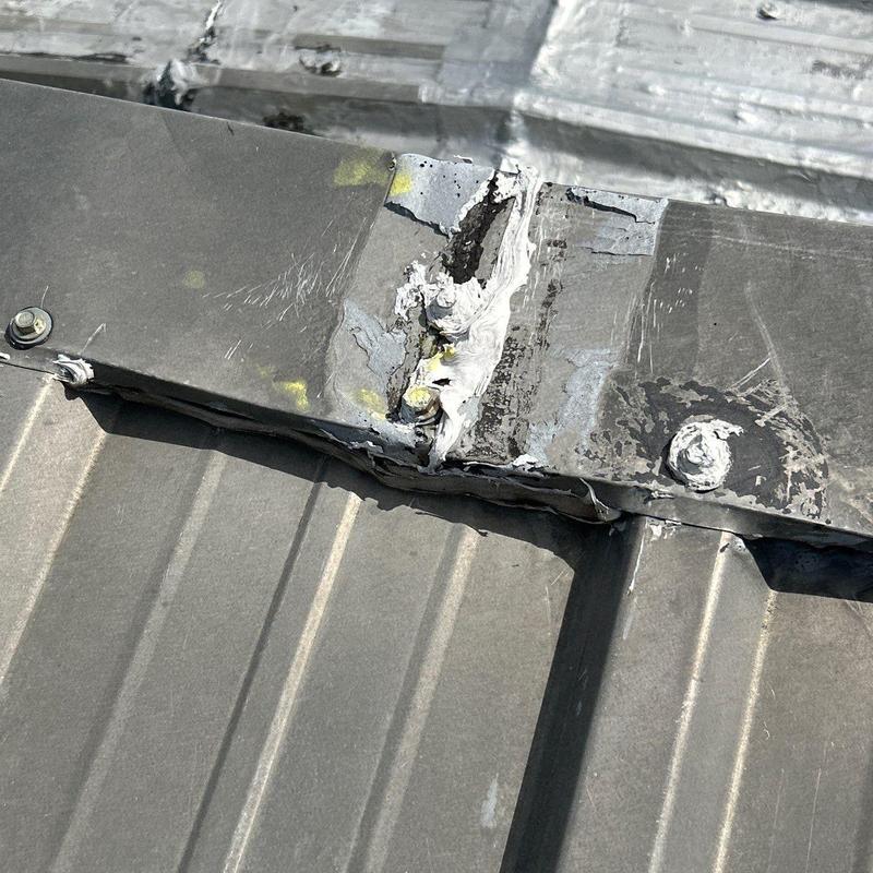 Metal roof flashing with sealant and damage repairs