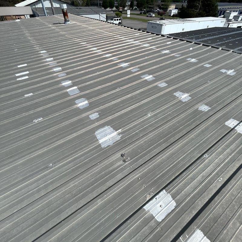 Metal roof with patched hail damage spots