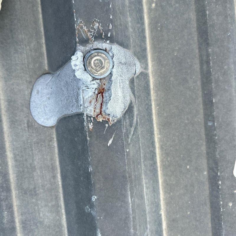 Metal roof screw with sealant and rust stains