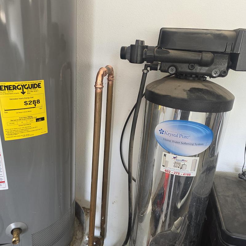 Water softener unit next to water heater in home