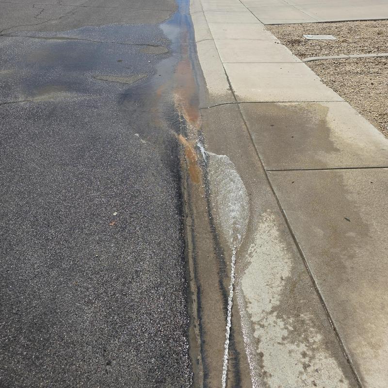 Water softener leak flushing water along curb and sidewalk