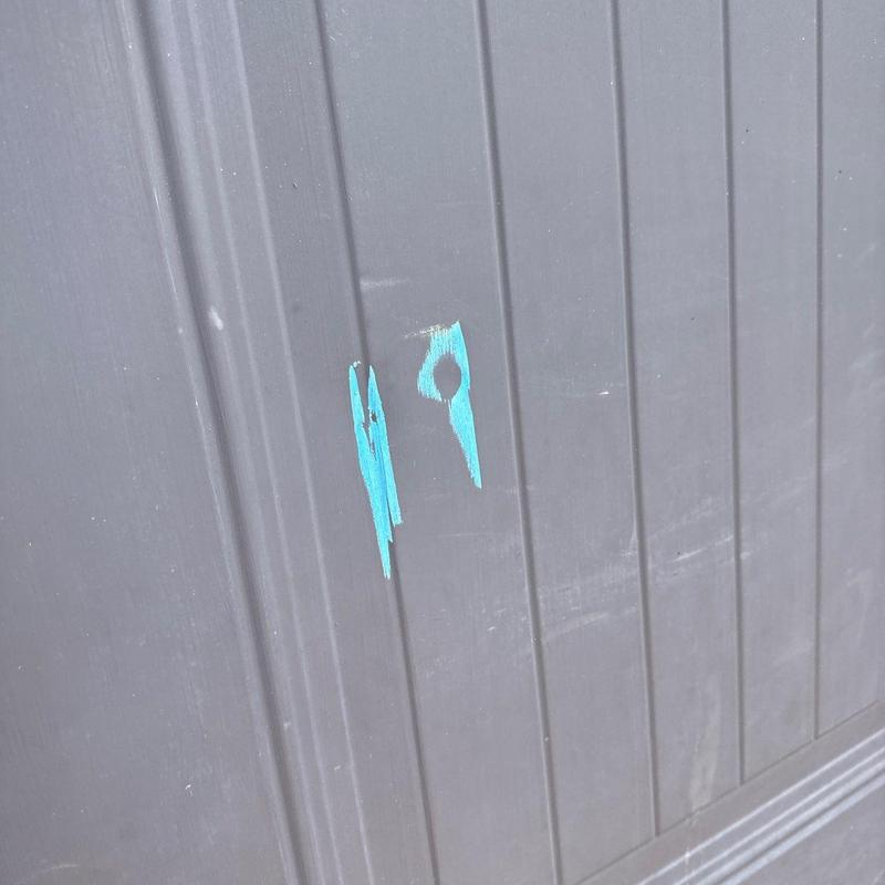 Garage door panel with blue paint marks