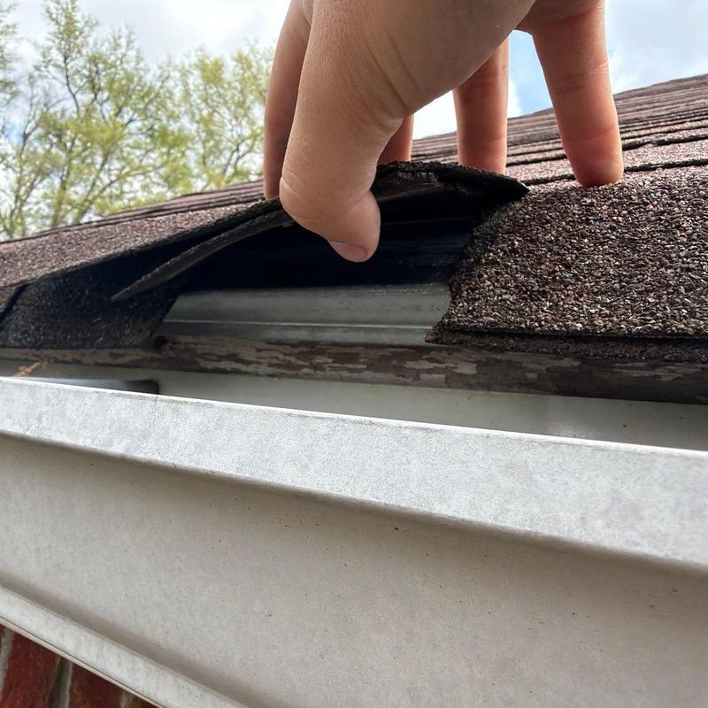 Asphalt shingle lifting showing potential roof damage