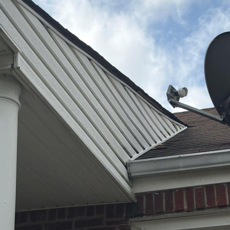Roof flashing and siding at roof junction with satellite dish