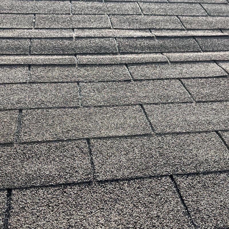 Asphalt shingles with hail damage on roof surface
