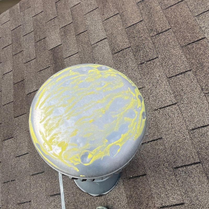 Roof vent cap with hail damage marked in yellow on shingles