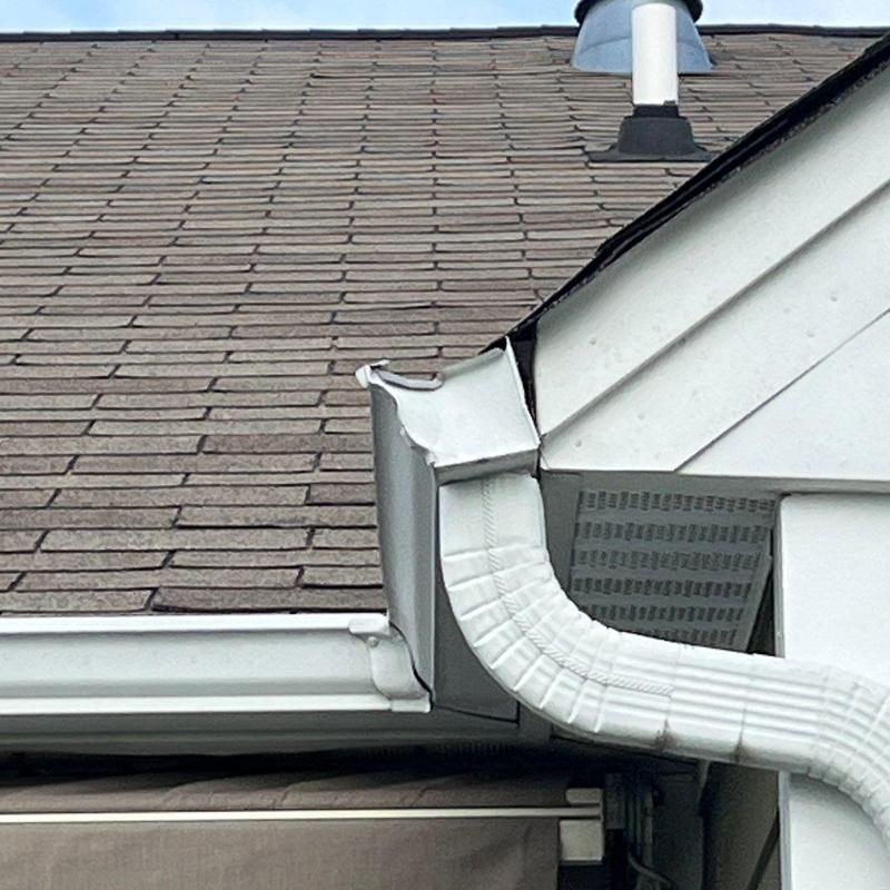 Gutter downspout with damaged corner section on roof edge