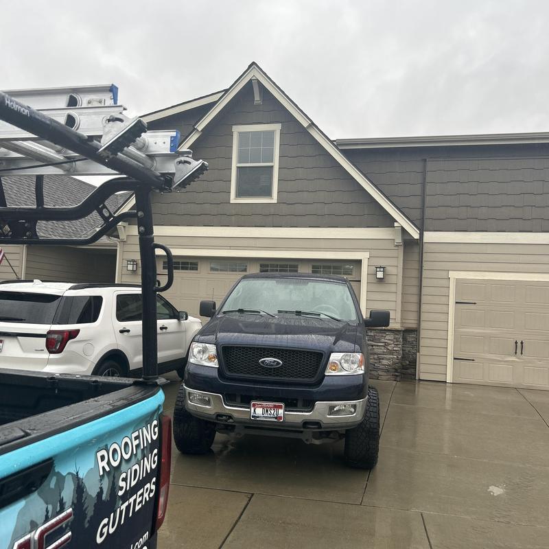 Roof leak emergency repair truck at residential home driveway