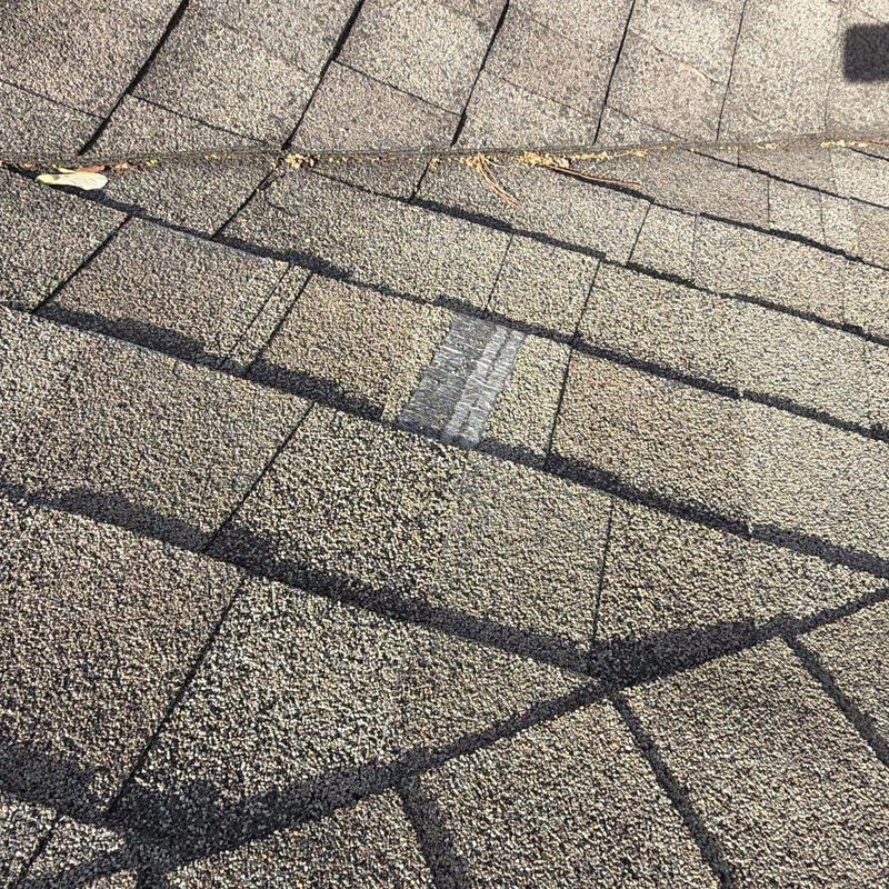Roof shingles with hail damage and repair patch