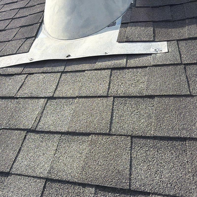 Roof shingles and metal flashing with hail damage signs