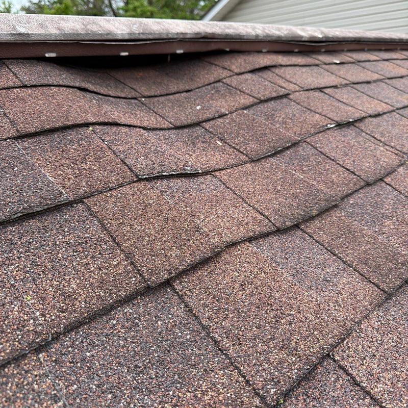 Asphalt shingles with hail damage on roof surface