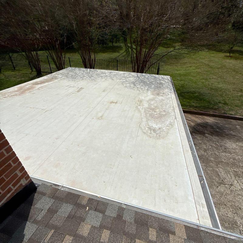 Flat roof membrane with wear and discoloration near edge