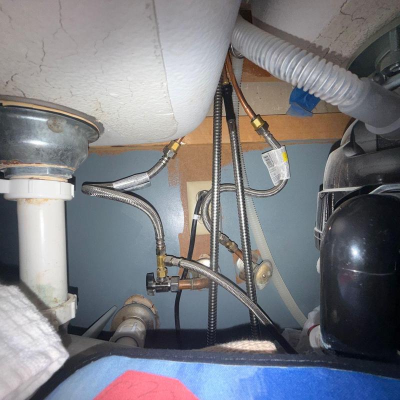 Kitchen sink water supply lines and drain plumbing under sink