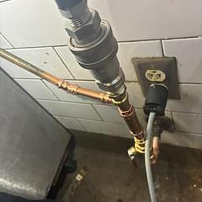 Flexible water connectors and ball valve behind kitchen equipment Flexible water connectors and ball valve behind kitchen equipment