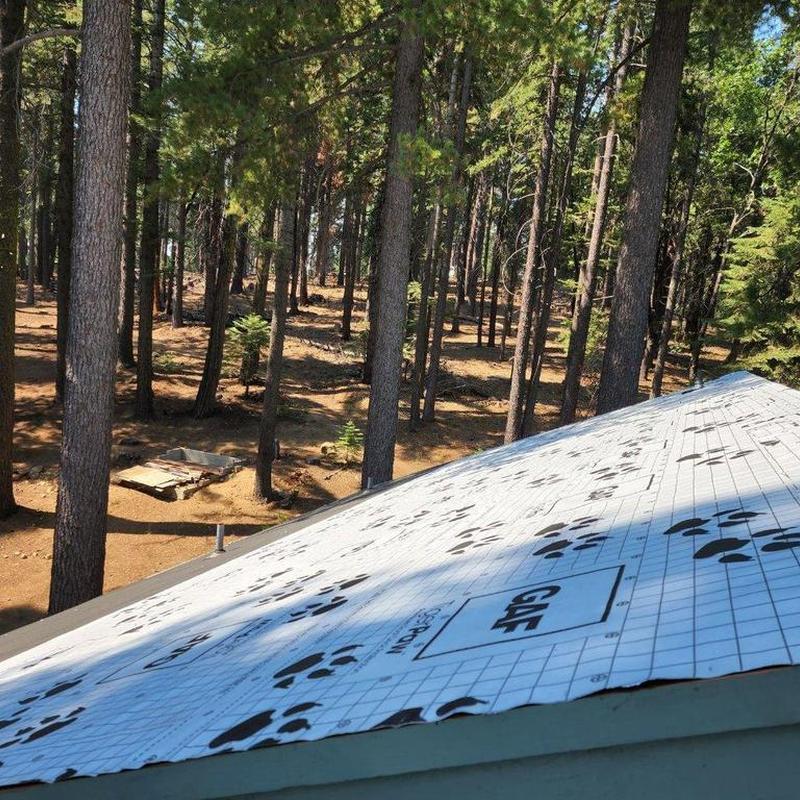 GAF underlayment installation on cabin roof in forest