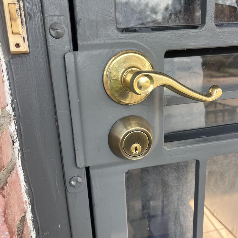 Deadbolt lock on gray metal security gate Deadbolt lock on gray metal security gate