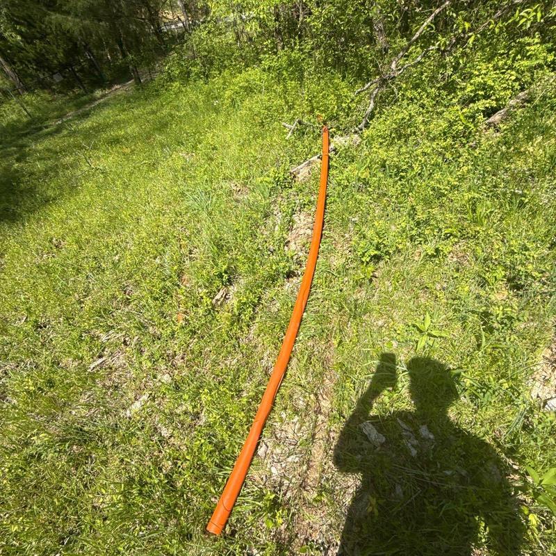 Gas line in grassy outdoor area with technician shadow