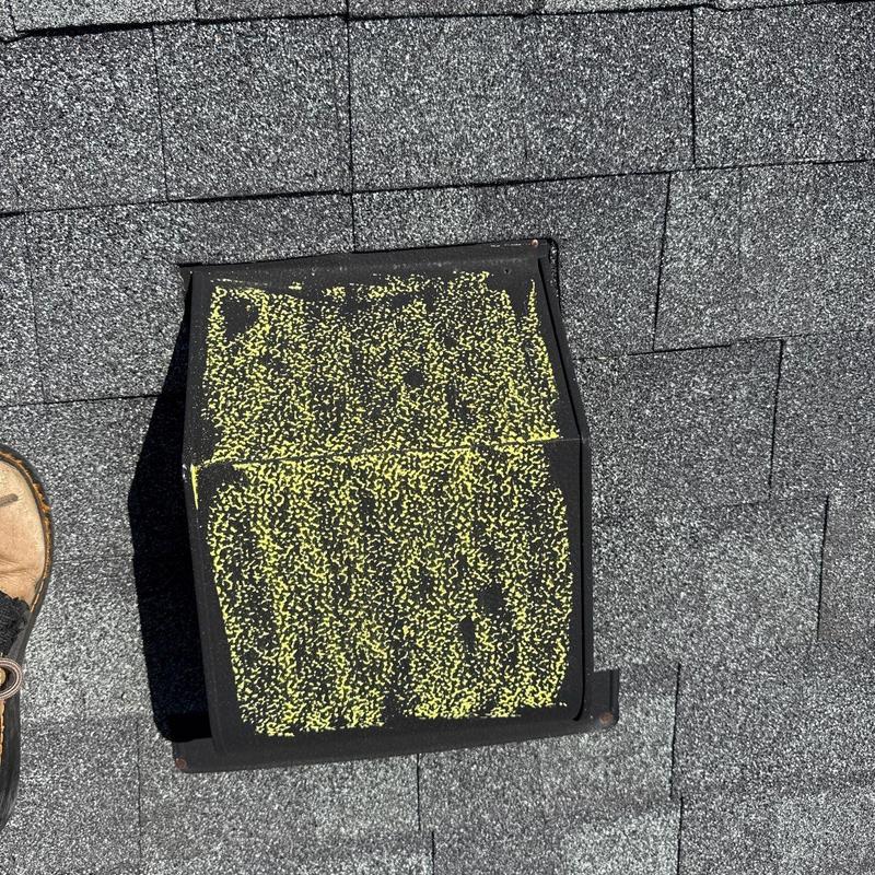 Roof vent with hail damage marked in yellow on shingles