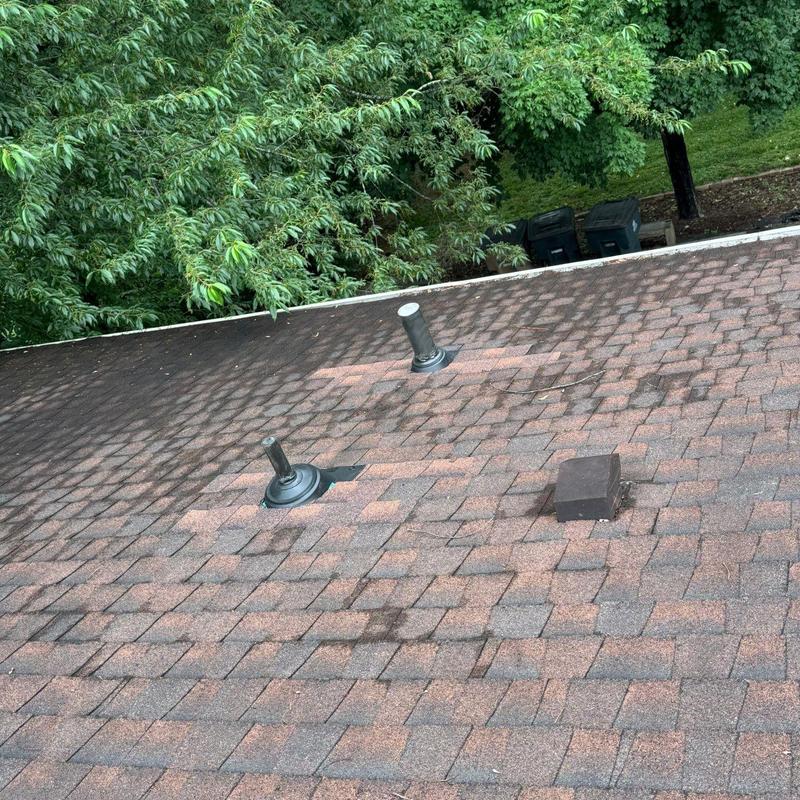 Asphalt shingle roof with damaged vents and shingles