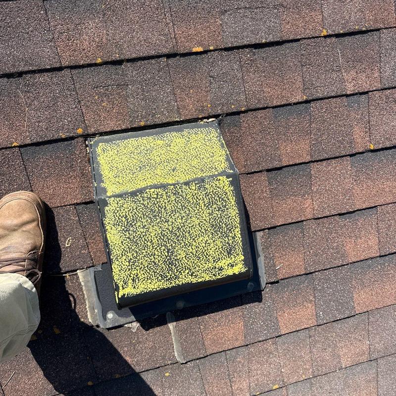 Roof vent with hail impact marks on shingles