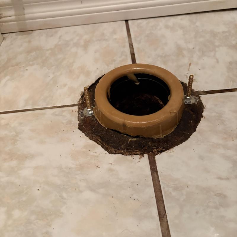 Toilet flange and wax ring on tiled floor Toilet flange and wax ring on tiled floor