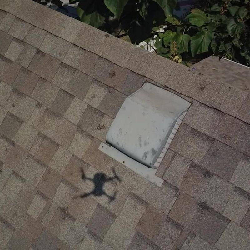 Roof vent on asphalt shingle roof with debris marks