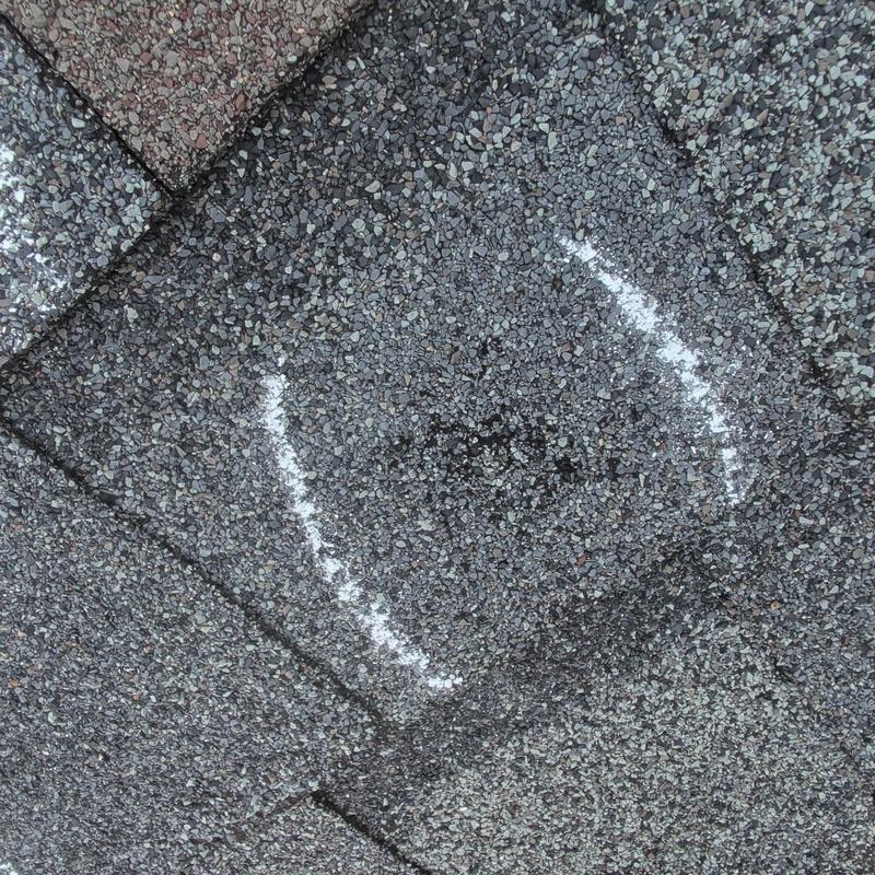 Asphalt shingle roof with marked hail damage