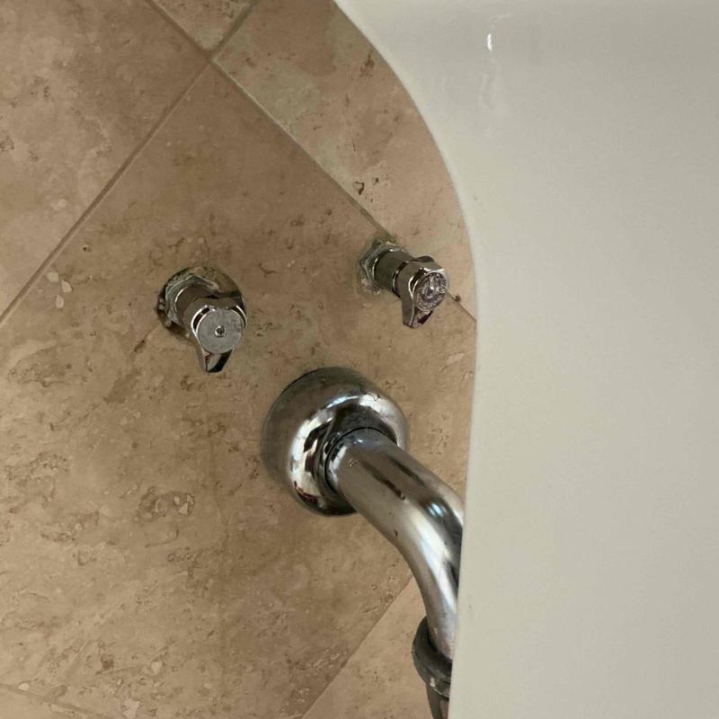 Hot and cold angle stops behind bathroom sink Hot and cold angle stops behind bathroom sink