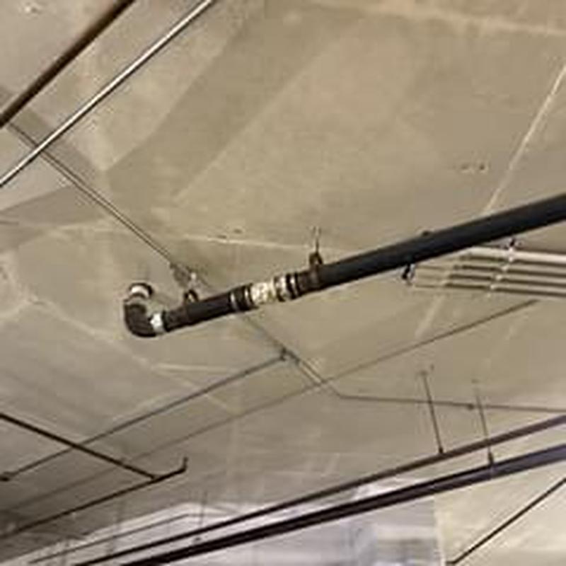 Black iron pipe with multiple fittings under ceiling