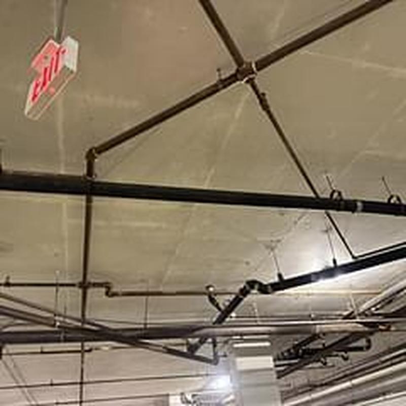 Cast iron drain pipes with hydro jet cleaning in garage ceiling
